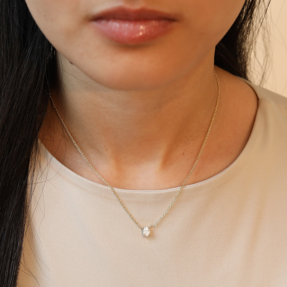 Model draagt een 14 karaat gouden ketting met ovale diamant van 0.3 karaat